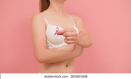 Pnk October, Brest Cancer Awareness Ribbon In The Hand Of A Young Unrecognzable Woman. High Quality Photo