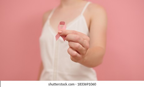 Pnk October, Brest Cancer Awareness Ribbon In The Hand Of A Young Unrecognzable Woman. High Quality Photo