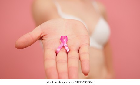 Pnk October, Brest Cancer Awareness Ribbon In The Hand Of A Young Unrecognzable Woman. High Quality Photo