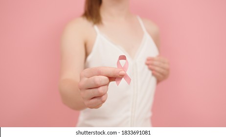 Pnk October, Brest Cancer Awareness Ribbon In The Hand Of A Young Unrecognzable Woman. High Quality Photo