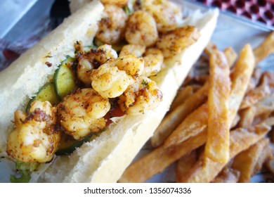 Po Boy sandwich with shrimp, lettuce and pickles on fresh baked bread. A New Orleans classic                               