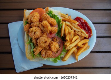 A Po Boy shrimp sandwich with French Fries and ketchup on the side found in Key West, Florida