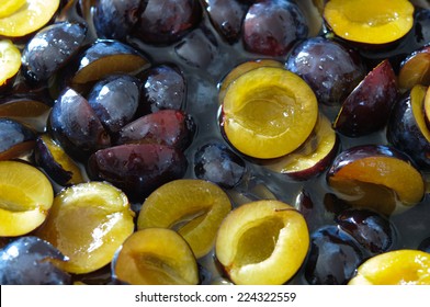 Poached cutted plums in sugar syrup