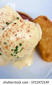 Poached Egg With Hollandaise Sauce And Hash Brown On A White Plate Top View. Healthy Breakfast.