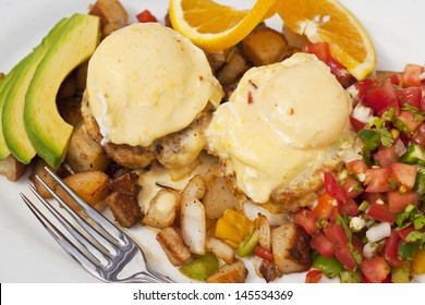 Poached Eggs Over Dungeness Crab Cakes With Chipotle Hollandaise Sauce On A Bed Of Roasted Potatoes