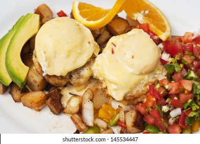 Poached Eggs Over Dungeness Crab Cakes With Chipotle Hollandaise Sauce On A Bed Of Roasted Potatoes