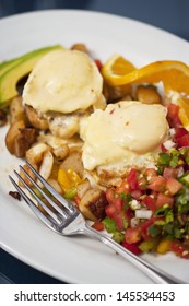 Poached Eggs Over Dungeness Crab Cakes With Chipotle Hollandaise Sauce On A Bed Of Roasted Potatoes