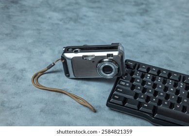 Pocket camera and computer keyboard on the table