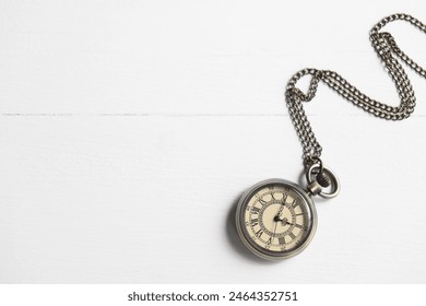 Pocket clock with chain on white wooden table, top view. Space for text - Powered by Shutterstock