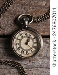 Pocket clock with chain on wooden table, top view