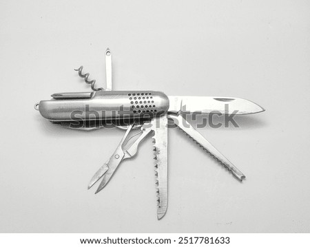 Pocket knife opened with many tools available in isolated white background