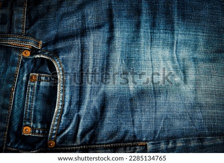pocket and small pocket in faded blue jeans