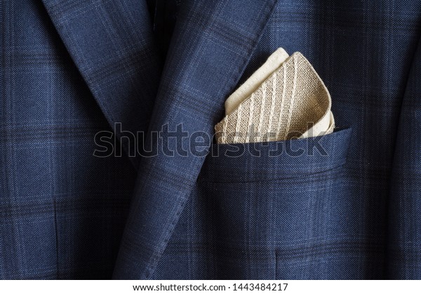 Pocket square with embroidery in the\
breast pocket of a man\'s blue suit. Wedding\
accessories