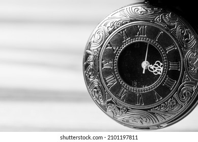 Pocket watch, beautiful details of a pocket watch positioned on a rustic wooden surface, selective focus.
