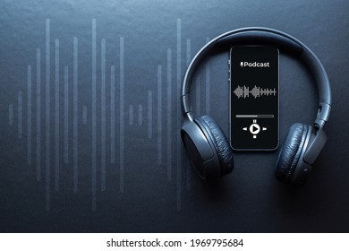 Podcast audio equipment. Audio microphone, sound headphones, podcast application on mobile smartphone screen. Recording sound voice on dark background. Live online radio player mockup banner - Shutterstock ID 1969795684