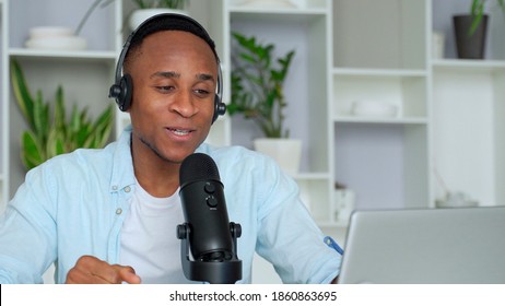 Podcast Concept - Happy Young Black Man Audio Blogger In Headphones With Laptop Computer And Microphone Broadcasting At Home Office