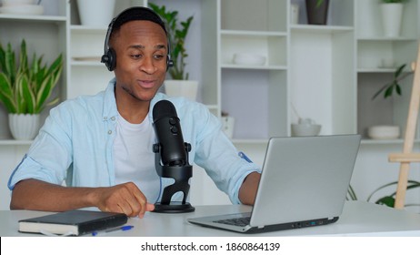 Podcast Concept - Happy Young Black Man Audio Blogger In Headphones With Laptop Computer And Microphone Broadcasting At Home Office