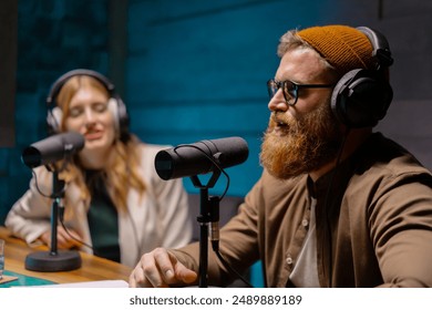 Podcast hosts engage in creative discussions in a studio setting while wearing headphones - Powered by Shutterstock