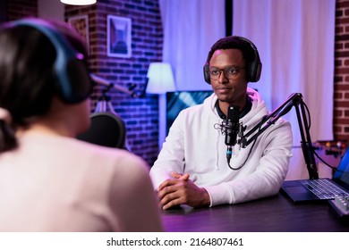 Podcast Presenter Recording Podcast Livestream At Sound Station, Using Modern Equipment For Audience. Male Influencer Interviewing Woman For Online Broadcast Discussion In Studio.