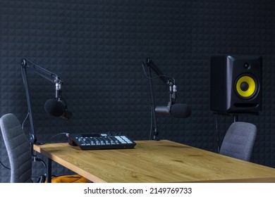 Podcast recording studio, with microphones and equalizer for recording online radio broadcasts, with black soundproof wall - Shutterstock ID 2149769733