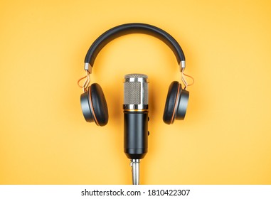 podcasting concept, directly above view of headphones and recording microphone on orange background - Shutterstock ID 1810422307