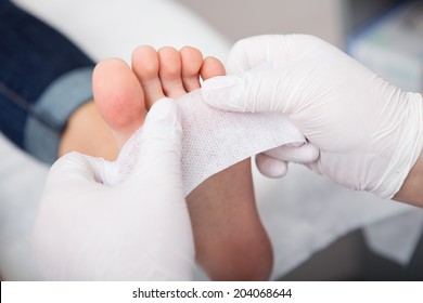 podiatrist ( chiropodist ) cleaning womans feet ( toenails )