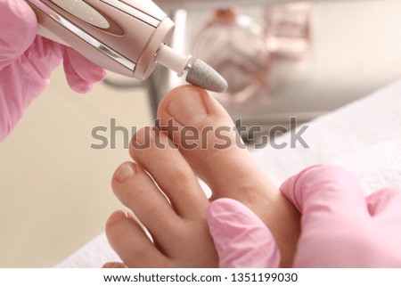 Podiatrist peeling feet of young woman in spa salon