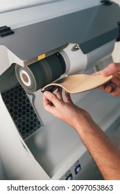 Podiatrist Sanding And Polishing An Orthopedic Foot Insole For A Patient.