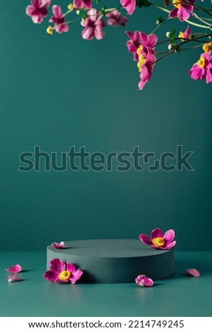 Podium, stand, showcase and brigth purple flowers on dark teal background. Mock up scene. Trendy color 2023