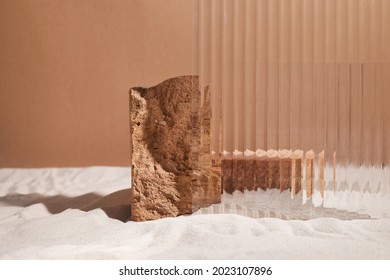 Podiumstand und strukturiertes Glas auf Sandhintergrund. Display für kosmetische Parfümmode mit Naturprodukt
