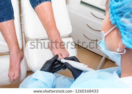 Podology treatment. Podiatrist treats foot. Podiatry doctor or dermatologist treats the patient in modern clinic