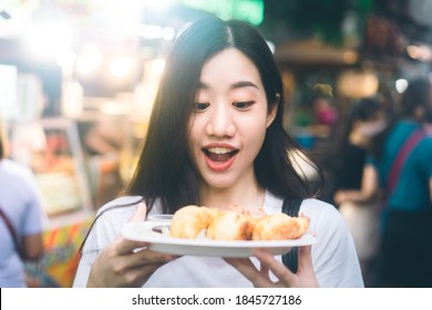 Poeple Travel And Eating Street Food Concept. Happy Young Adult Asian Foodie Woman Holding Gyoza At Chinatown Yaowarat Market, Bangkok, Thailand.