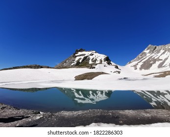 Poetic reflection of Alpine Lake near a high altitude trekking pass - Col de la Forcla - in Swiss Alps