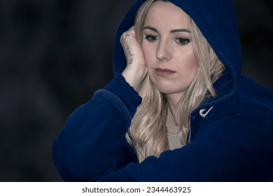 The Poignant Expression of a Young, Beautiful Blonde Woman in Hoodie