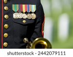 A poignant moment unfolds as a Marine plays taps, honoring a fallen veteran with a solemn salute, marking their internment at a national military cemetery.