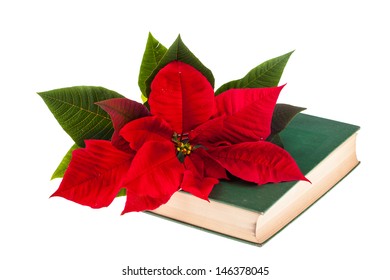 A Poinsetta Flower On The Top Of An Old Book Isolated On White