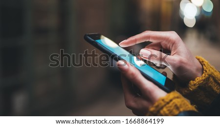 point finger on screen mobile phone closeup, person texting text message, hipster touch blue screen on smartphone light night city, girls using in hands cellphone close up, online wi-fi internet