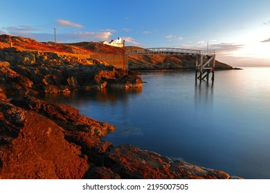 Point Lynas Lighthouse At First Light With Calm Blue Sea. Anglesey, North Wales, UK.