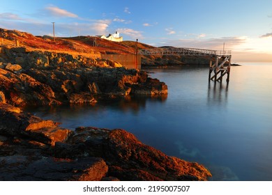 Point Lynas Lighthouse At First Light With Calm Blue Sea. Anglesey, North Wales, UK.