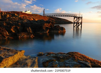 Point Lynas Lighthouse At First Light With Calm Blue Sea. Anglesey, North Wales, UK.