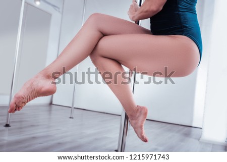 Point toes. Professional pole dancer feeling exhausted while pointing her toes while training all day