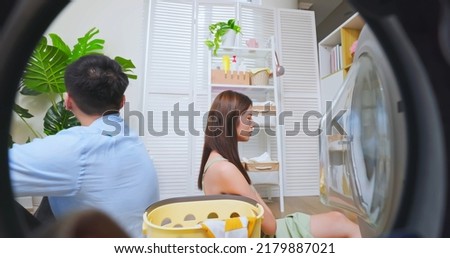 point of view asian couple have an arguement about the laundry - they turn around face another side against each other