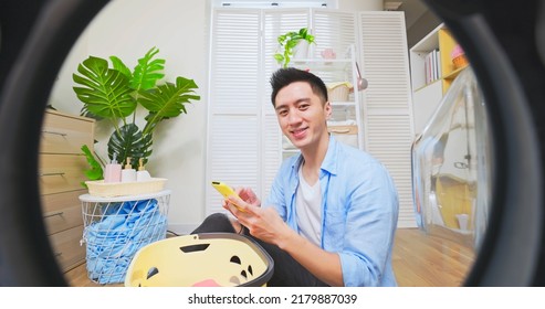 Point Of View Asian Man Doing Laundry With Smartphone Controlling