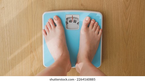 point of view - closeup feet for asian woman measure weight on scale - Powered by Shutterstock