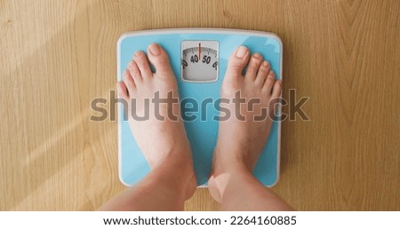 point of view - closeup feet for asian woman measure weight on scale