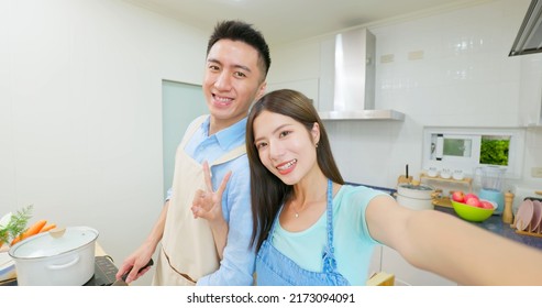 Point Of View Healthy Asian Young Couple Wearing Apron Are Cooking And They Taking Selfie Through Mobile Phone In Light White Interior Style Kitchen At Home