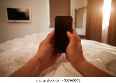 Point Of View Image Of Person In Bed Looking At Mobile Phone