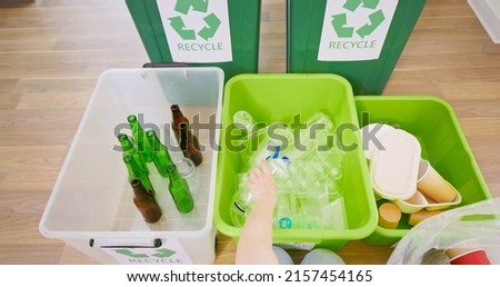 point of view - kid sorting garbage at home recycling rusing glass plastic and paper for sustainable waste management system