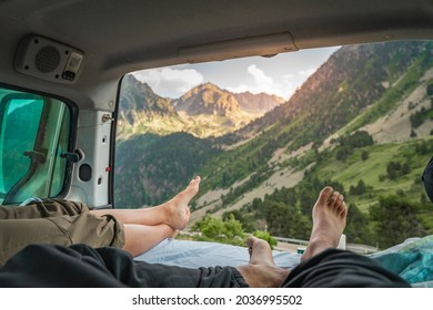 Point of view of legs of romantic couple inside old van enjoying the amazing landscape together - Adult man and woman enjoy summer travel vacation in camper van. Van life. - Powered by Shutterstock