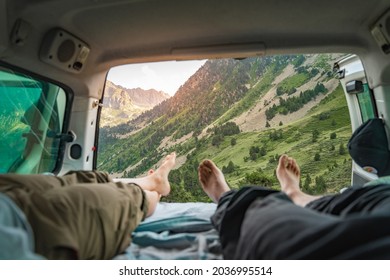 Point of view of legs of romantic couple inside old van enjoying the amazing landscape together - Adult man and woman enjoy summer travel vacation in camper van. Van life. - Powered by Shutterstock